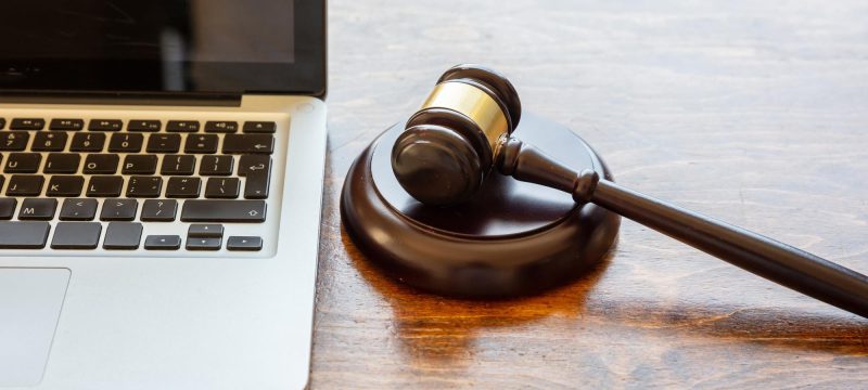 judge-gavel-laptop-wooden-background