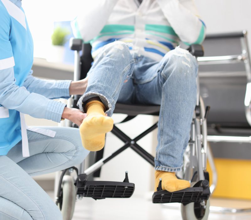 rehabilitation-doctor-helping-lift-leg-patient